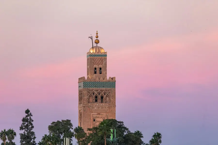Koutoubia Mosque minaret silhouetted against a pastel sunset sky in Marrakech