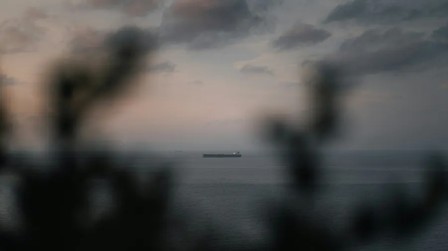 Cargo ship crossing the Strait of Gibraltar at dusk off the Tangier coast