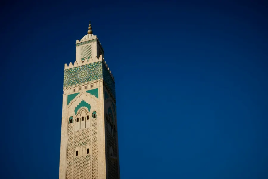 Minaret of Hassan II Mosque in Casablanca against a deep blue sky