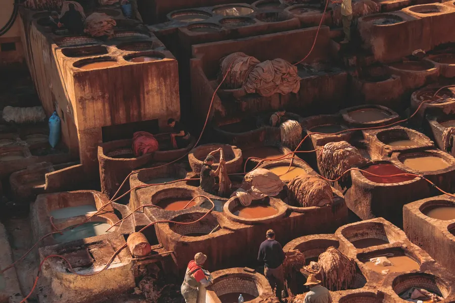 Tanners working in stone dye pits at Chouara Tannery in Fes