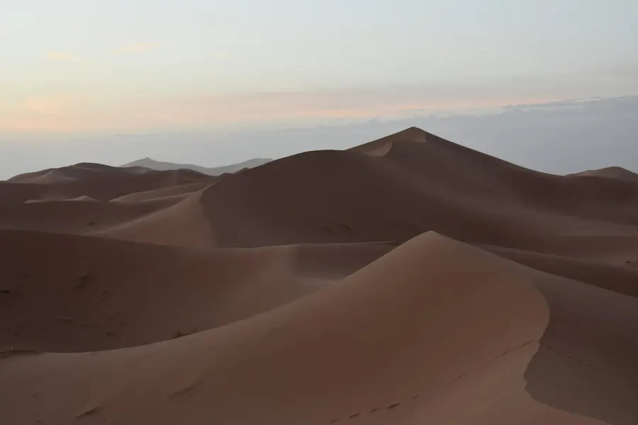 Crests of the Erg Chebbi sand dunes in Merzouga under pale dusk sky