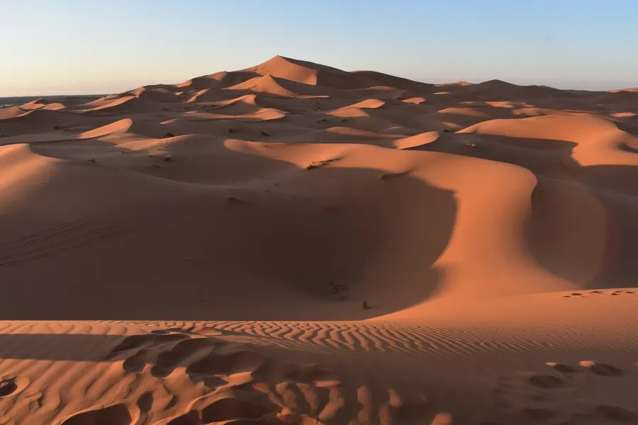 Expansive view of rolling Sahara sand dunes at sunset in Merzouga