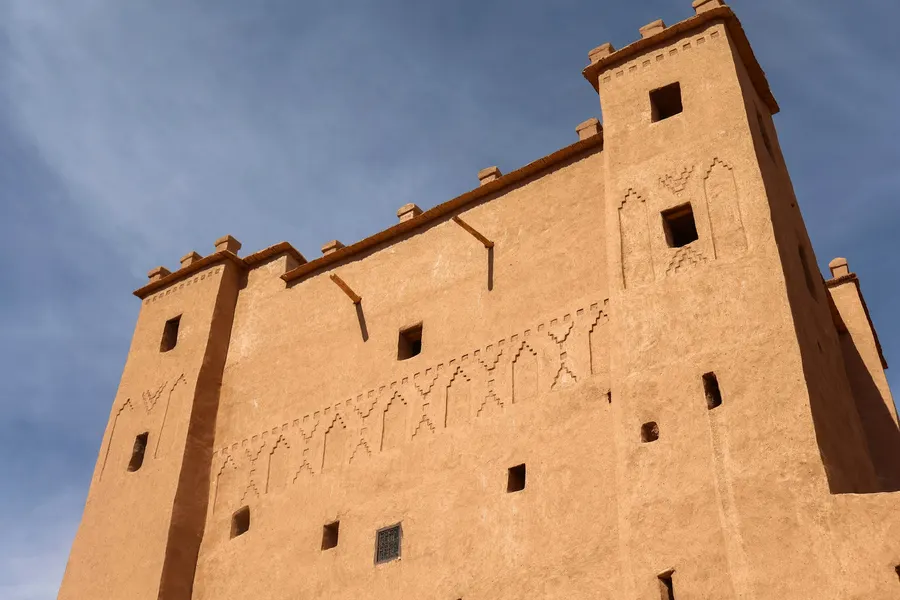 Fortified mudbrick kasbah tower with geometric patterns against the sky
