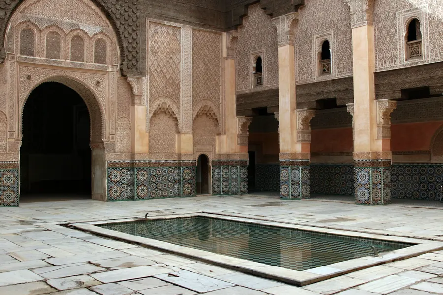 Vasca riflettente nella corte decorata a stucco della Medersa Ben Youssef a Marrakech