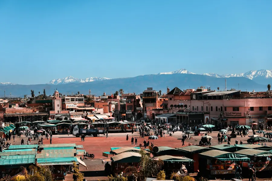 Vista panorámica de la plaza Jemaa el-Fna en Marrakech con las montañas del Alto Atlas