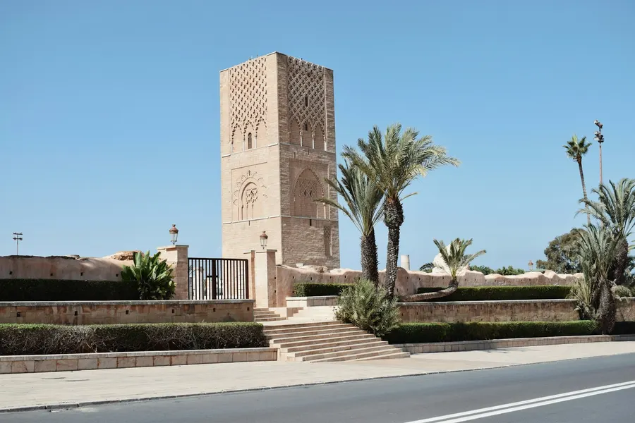 Alminar de la Torre Hassan elevándose tras las palmeras en Rabat