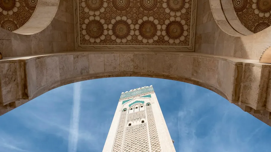 Minarete de la Mezquita Hassan II enmarcado por un arco morisco tallado